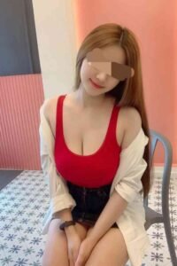 Woman in red top and white shirt sitting on chair