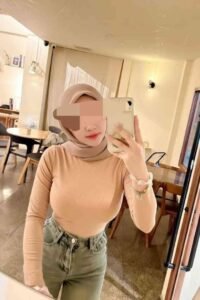 Woman in hijab taking a selfie in a cafe.