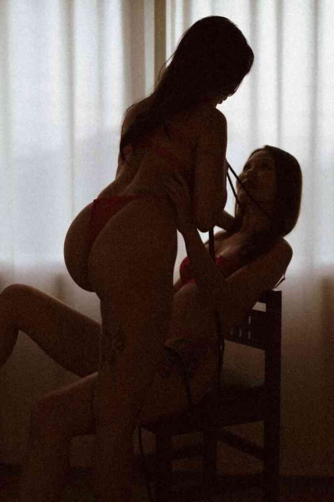 Viola and Cici in intimate embrace, soft lighting
